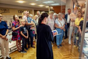 Beata Domagała opowiada o technikach ikonopisarstwa w otoczeniu uczestników otwarcia
